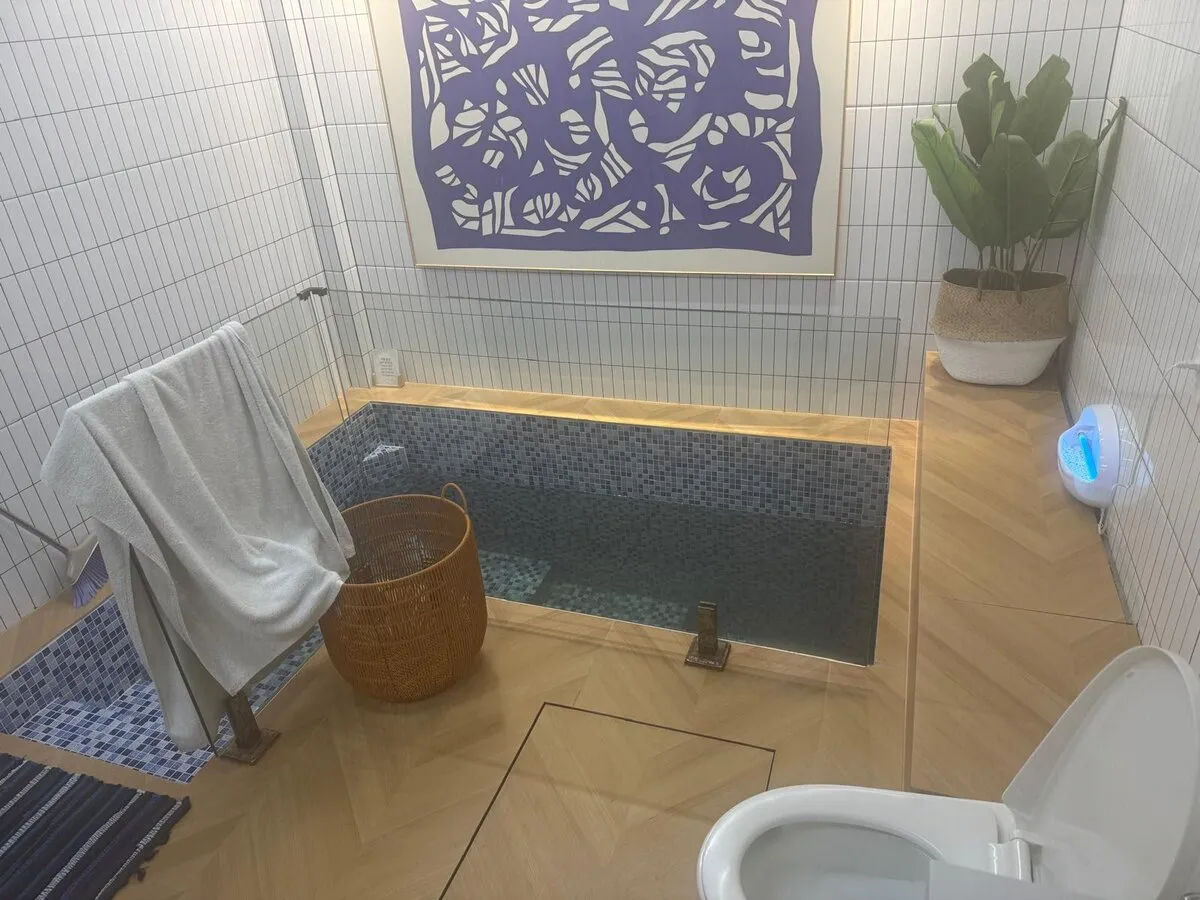 Beautiful modern mikvah with blue mosaic tiles and warm wood